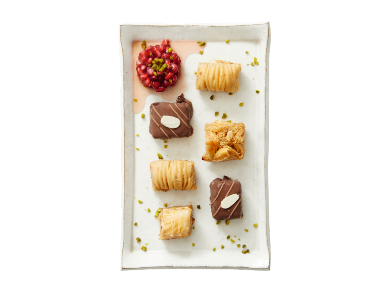 Assortment of baklava and chocolate sweets with pomegranate and pistachios.
