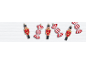 Christmas ornaments of toy soldiers and red and white striped candies on white wood.