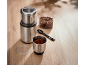 Electric coffee grinder with coffee beans and ground coffee on a wooden table.