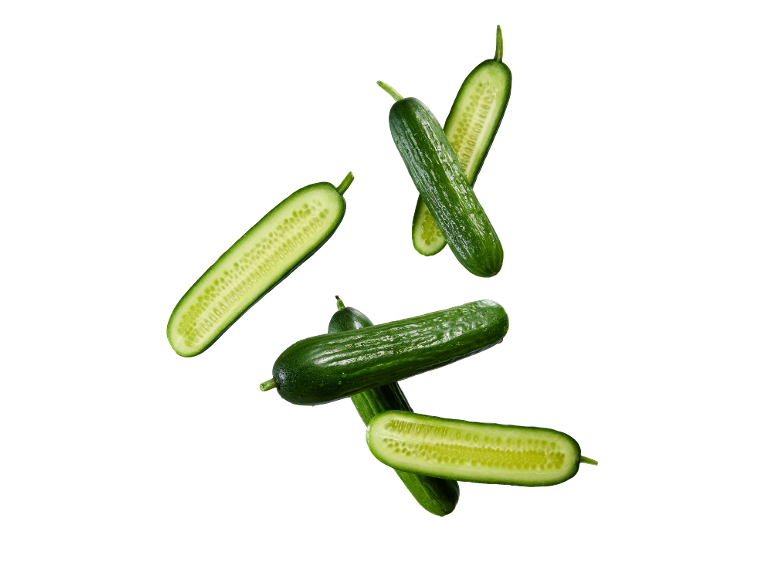 Fresh cucumbers, whole and cut in half, on a black background.