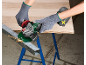 Gloved person using an angle grinder to cut a metal beam, sparks flying.