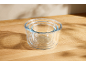 Set of three clear glass nesting bowls on a wooden surface with shadows.