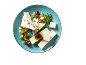Feta cheese with olives and fresh herbs on a blue plate.