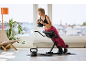 Woman exercising on a fitness bench with a black kettlebell in her hands.
