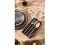 Elegant table setting with dark grey plates, silver cutlery on a napkin, and glassware.