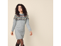 Woman in a knitted dress with a Nordic pattern and black boots.