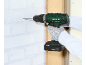 Cordless drill being used to drill a wall.
