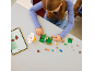 Girl building with toy bricks, following instructions on a tablet.