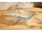 Set of nesting glass food storage containers on a wooden table.