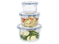 Stack of glass food storage containers with blue lids, filled with zucchini and bulgur.