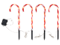 Four illuminated candy cane path lights with red and white stripes, connected by wires to a control box.