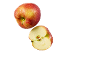 Red apple with water droplets and a cut half with seeds on a black background.