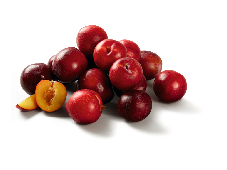 Pile of red plums, with one cut in half revealing the golden flesh.