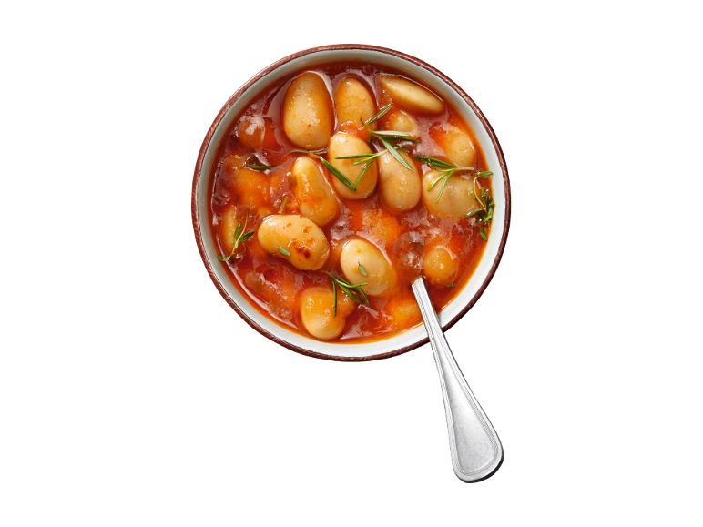 White beans in tomato sauce with rosemary in a bowl with a spoon