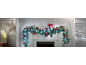 Lit Christmas garland with red baubles and gifts on a fireplace.