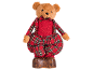 Teddy bear in red sweater and plaid trousers, on a leather base.