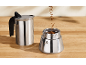 Coffee maker with ground coffee on a wooden table.