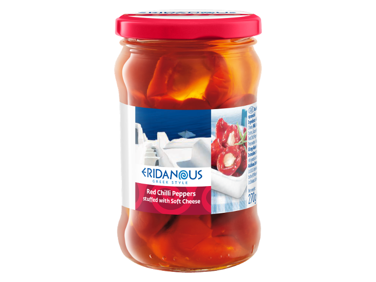 Red chili peppers stuffed with soft cheese in a glass jar, Greek style.