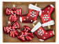 Red Christmas decorations with bows and boots with snowflakes in a cardboard box.