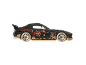 Black toy race car with orange patterns and beige wheels.