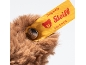 Brown plush toy with a yellow label reading 'Designed by Steiff Friends' and a metal button.