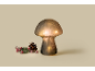 Mushroom-shaped lamp with a pinecone and frosted red berries on a light background.