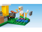 Lego figure in chicken suit cooking chicken outdoors, surrounded by small chicks and plants.