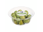 Green olives with pits in a transparent plastic container, with the label 