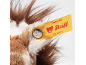 Brown and white plush toy fur with a yellow label that reads 'Designed by Friends'.