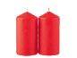 Two red pillar candles on a black background.