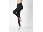 Woman in black compression leggings, posing sideways on a white background.