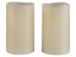 Two cream-colored LED pillar candles with wavy tops