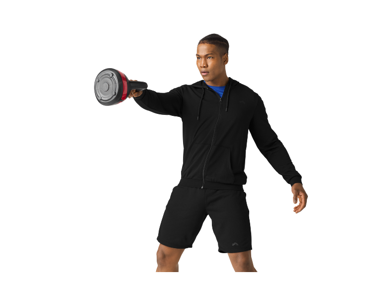 Man in black hoodie and shorts exercising with an ab roller.