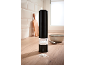 Black electric salt grinder with coarse salt on a wooden countertop.