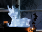Light-up Christmas reindeer with candles and winter decoration on a windowsill.