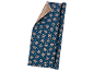 Blue wrapping paper with golden snowflakes and stars, a folded corner shows a lighter side with white snowflakes.