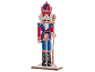 Wooden nutcracker soldier figure in a red and blue uniform.