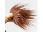 Close-up of the fluffy tail tip of a plush lion toy on a white background.