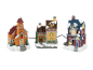 Christmas village set with church, house, and toy shop, covered in snow.