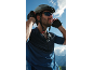 Man in a cycling helmet, sunglasses, and gloves against a sky background.