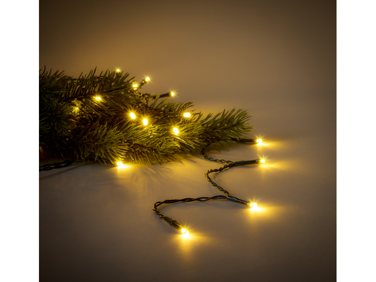 Christmas lights with warm yellow glow intertwined with green pine branches.