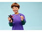 Smiling boy playing with a black and red toy action figure.