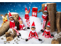 Six toy elves and a reindeer in a snowy setting with a postbox.