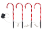 Four candy cane path lights with red and white stripes, connected by wires to a control box.