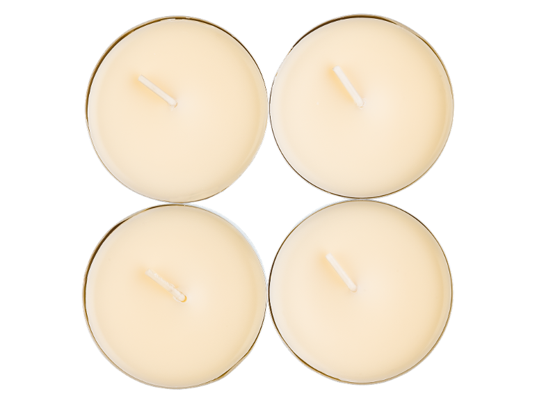 Four cream-colored round tea light candles with wicks in the center.