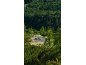 Two cyclists on a winding mountain road surrounded by dense forest.