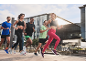 Group of runners in sportswear and shoes running through the city.