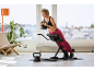 Woman doing back extensions with a kettlebell on an exercise bench.