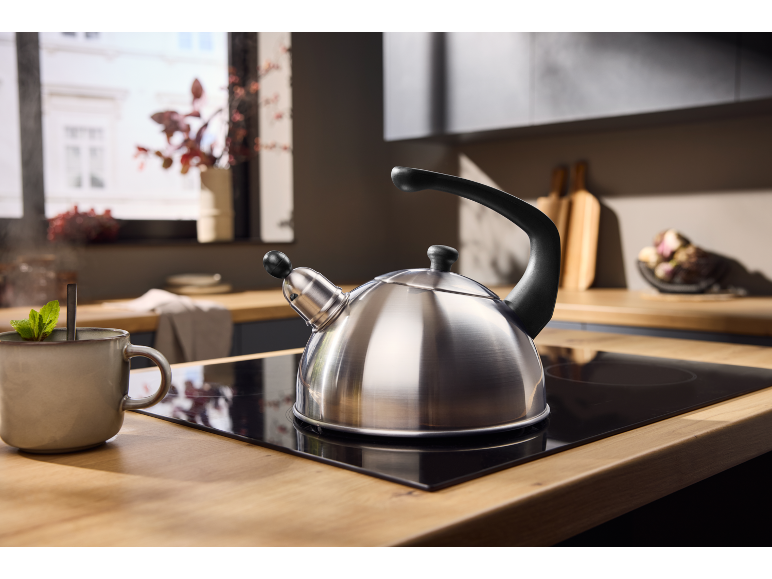 Kettle on hob with a cup of mint tea in the kitchen.