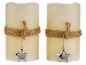 Two wax candles with jute rope and a silver star pendant.